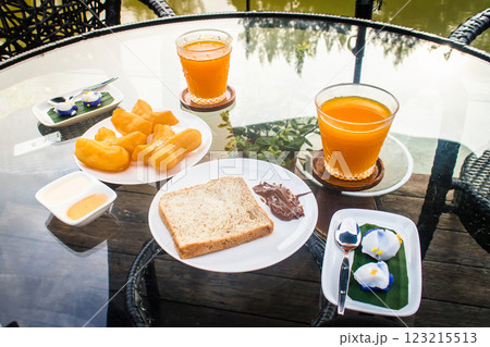 Breakfast spread with juice on a sunny terrace Breakfast spread with juice on a sunny terrace 123215513