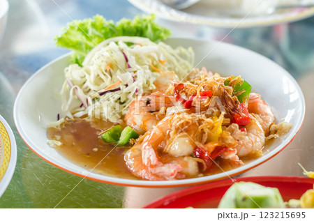 Shrimp dish with vegetables and sauce on a plate 123215695
