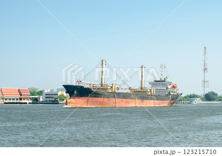 Cargo ship navigating a calm river scene. Cargo ship navigating a calm river scene. 123215710