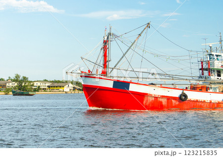 Fishing boat on water with bright red color scheme Fishing boat on water with bright red color scheme 123215835