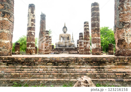 Ancient Buddha statue surrounded by ruins at Sukhothai Thailand Ancient Buddha statue surrounded by ruins at Sukhothai Thailand 123216158