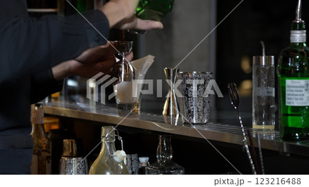 Closeup bartender holding jigger to measure lemon juice into shaker. Vinosity. Closeup bartender holding jigger to measure lemon juice into shaker. Vinosity. 123216488