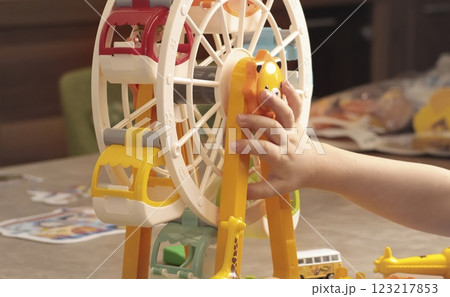 Child plays with a plastic constructor at home on table. Children and educational games. Animals of Africa and an amusement park. Child plays with a plastic constructor at home on table. Children and educational games. Animals of Africa and an amusement park. 123217853