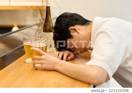 酒を飲みすぎて酔っ払う男性 123220306