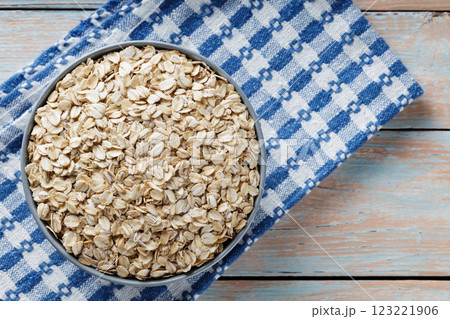 Oat Flakes in Gray Bowl on Blue-White Checkered Napkin, Copy Space 123221906