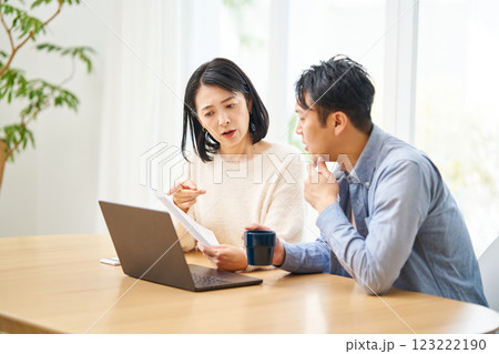 紙の書類を見て不信感を抱く夫婦 123222190