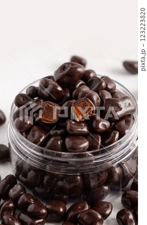 Chocolates with filling in a transparent glass jar. White wooden background. Close-up. Chocolates with filling in a transparent glass jar. White wooden background. Close-up. 123223820