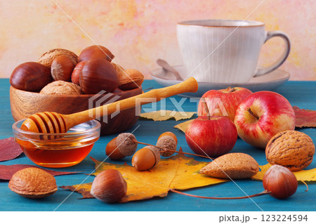 Blue wooden table with apples, nuts, chestnuts and honey Blue wooden table with apples, nuts, chestnuts and honey 123224594