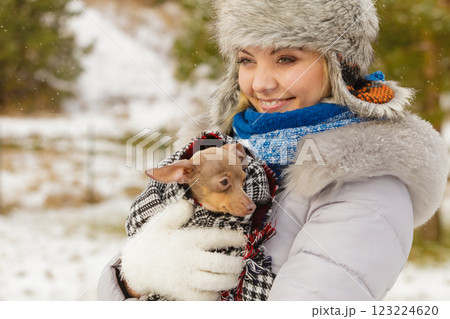 Woman hug warming her little dog in winter Woman hug warming her little dog in winter 123224620