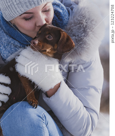 Woman playing with dog during winter Woman playing with dog during winter 123224708