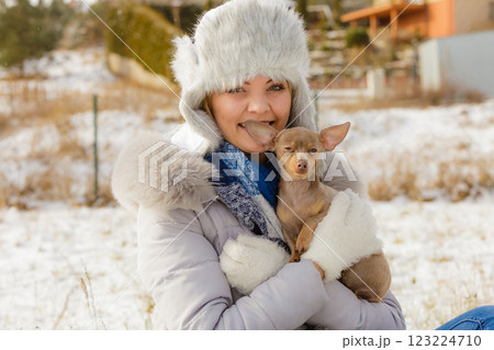 Woman playing with dog during winter 123224710