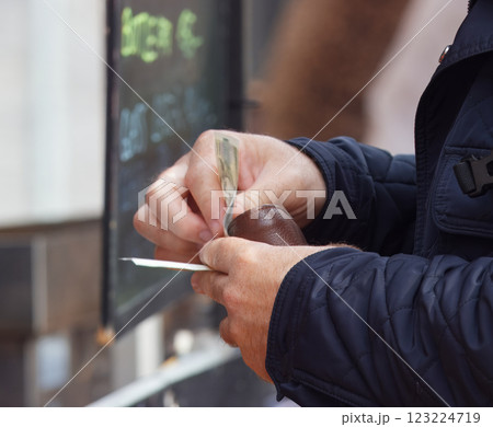 Person counting money at an outdoor market transaction Person counting money at an outdoor market transaction 123224719