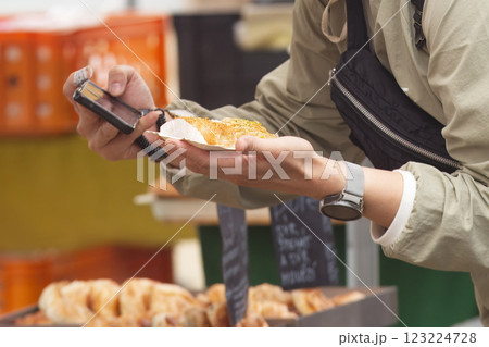 Person Photographing Food at a Market with a Smartphone 123224728
