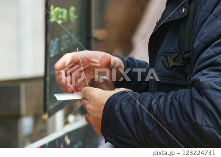Person counting money at an outdoor market transaction 123224731