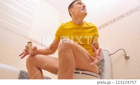 Man sitting on toilet discovering no toilet paper Man sitting on toilet discovering no toilet paper 123224757