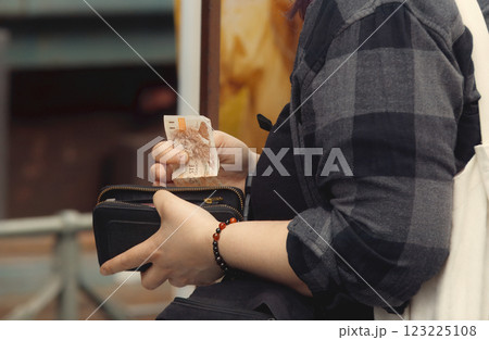 A customer, holding wallet and money and paying at outdoor farmers market 123225108