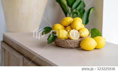 Organic ripe lemons with leaves resting in rustic woven basket 123225816