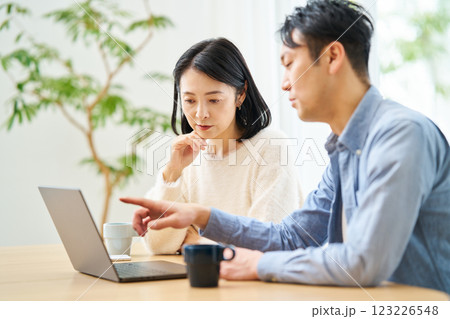 パソコンのモニターを見ながら話し合う夫婦 パソコンのモニターを見ながら話し合う夫婦 123226548