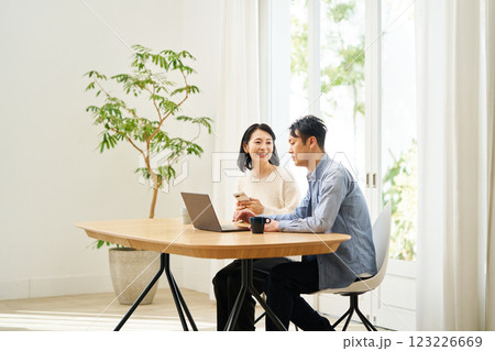 パソコンのモニターを見ながら話し合う夫婦 123226669