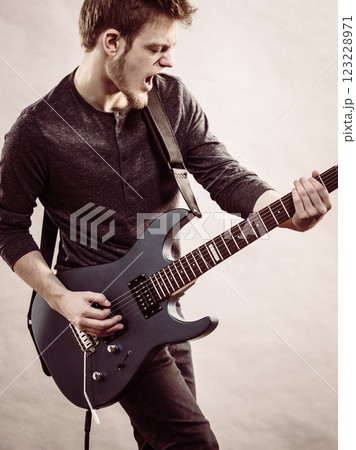 Young man playing electric guitar Young man playing electric guitar 123228971