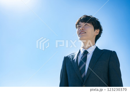 空に向かって立つスーツを着た男性 123230370