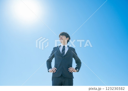 空に向かって立つスーツを着た男性 空に向かって立つスーツを着た男性 123230382