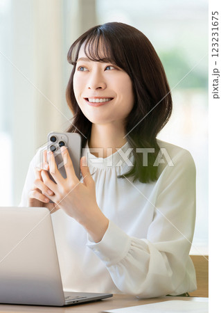 パソコンとスマートフォンを使う笑顔の女性・ビジネスウーマン 123231675