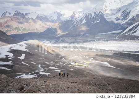 Group of mountaineers descending back to camp surrounded by magnificent alpine landscape of Pamir Group of mountaineers descending back to camp surrounded by magnificent alpine landscape of Pamir 123232894