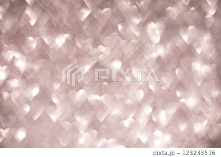 Soft glowing hearts create a romantic bokeh effect on a light pink background 123233516
