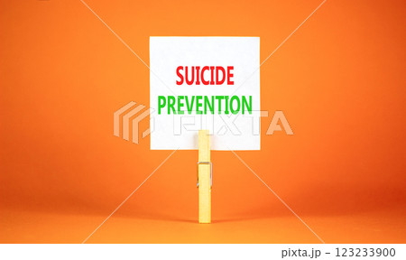 Suicide prevention symbol. Concept words Suicide prevention on beautiful white paper on clothespin. Beautiful orange table orange background. Psychological and suicide prevention concept. Copy space. Suicide prevention symbol. Concept words Suicide prevention on beautiful white paper on clothespin. Beautiful orange table orange background. Psychological and suicide prevention concept. Copy space. 123233900