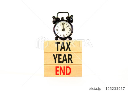 Tax year end symbol. Concept words Tax year end on beautiful wooden blocks. Beautiful white background. Black alarm clock. Business tax year end concept. Copy space. Tax year end symbol. Concept words Tax year end on beautiful wooden blocks. Beautiful white background. Black alarm clock. Business tax year end concept. Copy space. 123233937