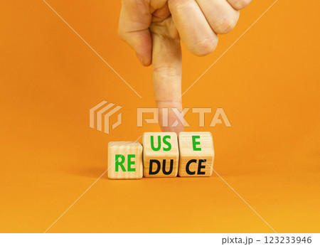 Reuse or reduce symbol. Concept words Reuse Reduce on wooden block. Beautiful orange table orange background. Businessman hand. Business reuse or reduce concept. Copy space. Reuse or reduce symbol. Concept words Reuse Reduce on wooden block. Beautiful orange table orange background. Businessman hand. Business reuse or reduce concept. Copy space. 123233946