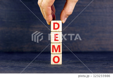 Demo symbol. Concept word Demo on beautiful wooden blocks. Businessman hand. Beautiful black table black background. Business and demo concept. Copy space. 123233986