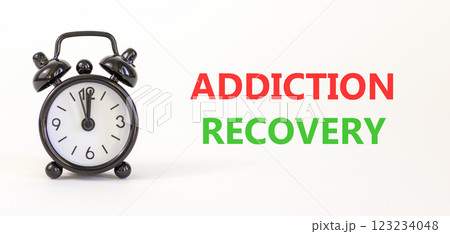 Addiction recovery symbol. Concept words Addiction recovery on beautiful white paper. Black alarm clock. Beautiful white paper background. Psychology addiction recovery concept. Copy space. 123234048