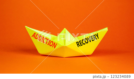 Addiction recovery symbol. Concept words Addiction recovery on beautiful yellow paper boat. Beautiful orange background. Psychology addiction recovery concept. Copy space. Addiction recovery symbol. Concept words Addiction recovery on beautiful yellow paper boat. Beautiful orange background. Psychology addiction recovery concept. Copy space. 123234089