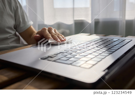 Meticulously Hand Cleaning Your Laptop with a Tissue to Achieve a Fresh and Neat Workspace 123234549