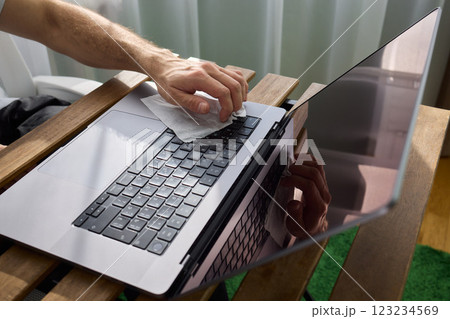 Meticulously Hand Cleaning Your Laptop with a Tissue to Achieve a Fresh and Neat Workspace Meticulously Hand Cleaning Your Laptop with a Tissue to Achieve a Fresh and Neat Workspace 123234569