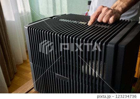 Hands adjusting a modern appliances control panel for optimal functionality and home comfort Hands adjusting a modern appliances control panel for optimal functionality and home comfort 123234736