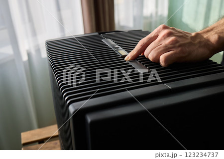 Hands adjusting a modern appliances control panel for optimal functionality and home comfort Hands adjusting a modern appliances control panel for optimal functionality and home comfort 123234737