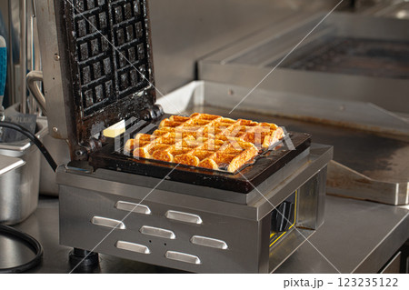 Cooking belgian waffles in the cafe kitchen Cooking belgian waffles in the cafe kitchen 123235122