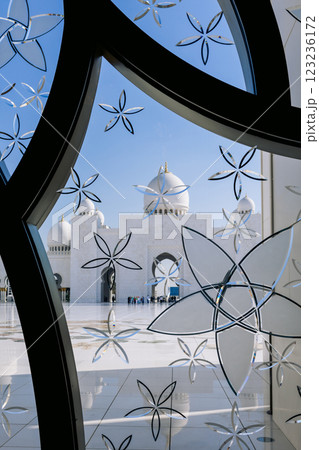 Sheikh Zayed Grand Mosque in Abu Dhabi made of white marble with flowers made of precious. Colored stained glass windows with blue flowers 123236172