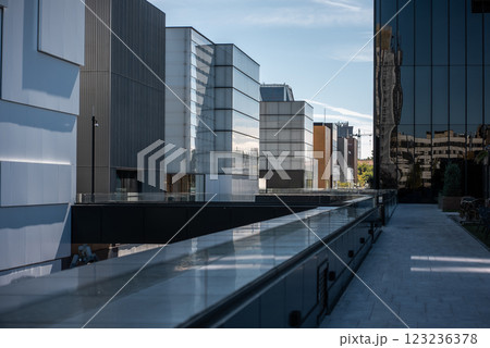 modern minimalistic architecture with glass facades and mirrors in vibrant urban setting during bright daylight, skyscrapers of Cuatro Torres area, Madrid 123236378