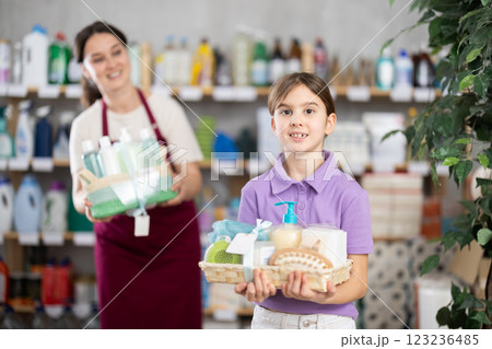 Female businesswoman with daughter stands in trading hall of household store, offer presents 123236485