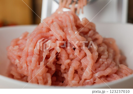 Close-up in a white plate is raw pink minced turkey, minced with a meat grinder. The concept of dietary nutrition, healthy and wholesome food, the cooking process. High quality photo 123237010