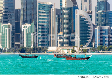 Doha modern business downtown center skyscrapers shoreline with small traditional arab dhow fishermen boats at the sea bay, Qatar Doha modern business downtown center skyscrapers shoreline with small traditional arab dhow fishermen boats at the sea bay, Qatar 123237460