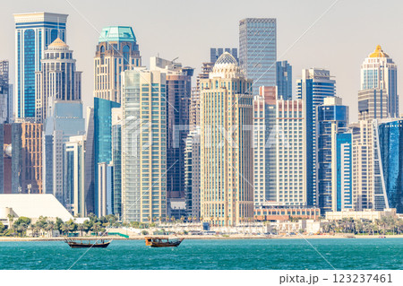 Doha modern business downtown center skyscrapers shoreline with small traditional arab dhow fishermen boats at the sea bay, Qatar 123237461