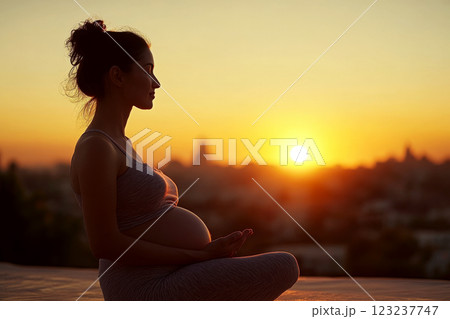 Pregnant woman sitting outdoors at sunset, practicing meditation. Concept of calm and anticipation. For articles on pregnancy wellness 123237747