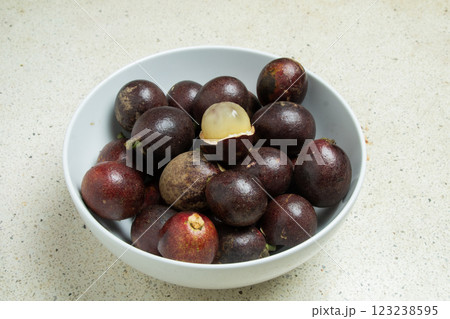 View of a white bowl containing matoa fruit (Pometia pinnata) which can be called betel nut 123238595