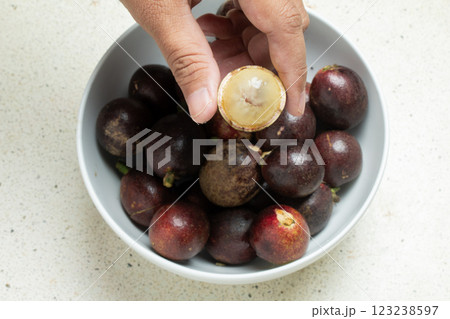 Closeup view of a hand showing a peeled betel nut or matoa fruit, a typical fruit of Papua, Indonesia 123238597