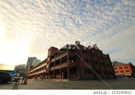 赤レンガ倉庫と夕日に照らされる建物 123240602